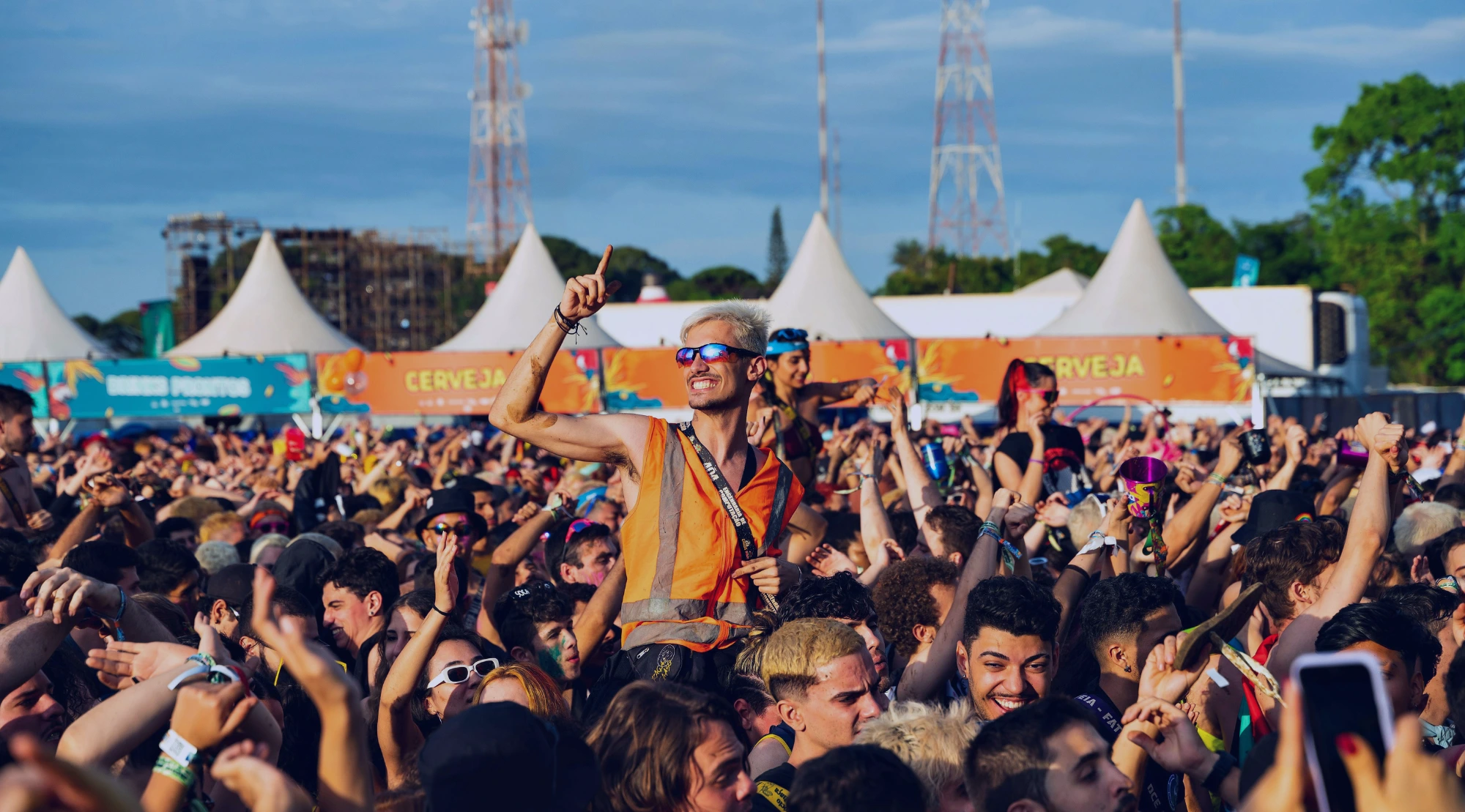 Große Festival-Crowd feiert bei einem Open-Air-Festival vor der Bühne.