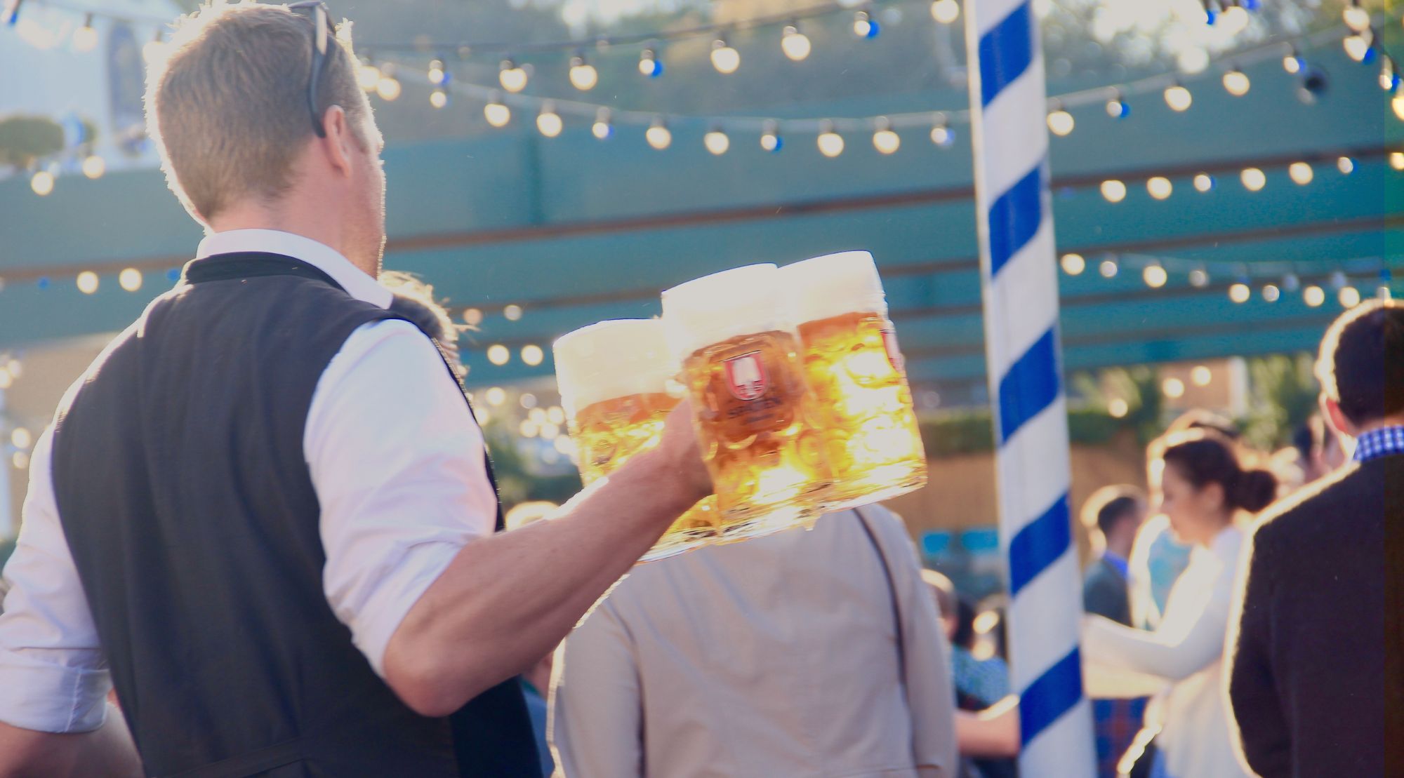 Ein Kellner serviert Bierkrüge auf dem Oktoberfest